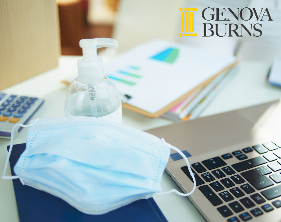 medical mask and hand disinfectant on table in office 